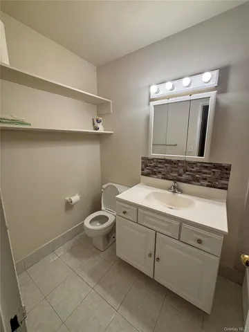 a bathroom with a granite countertop sink a toilet and vanity