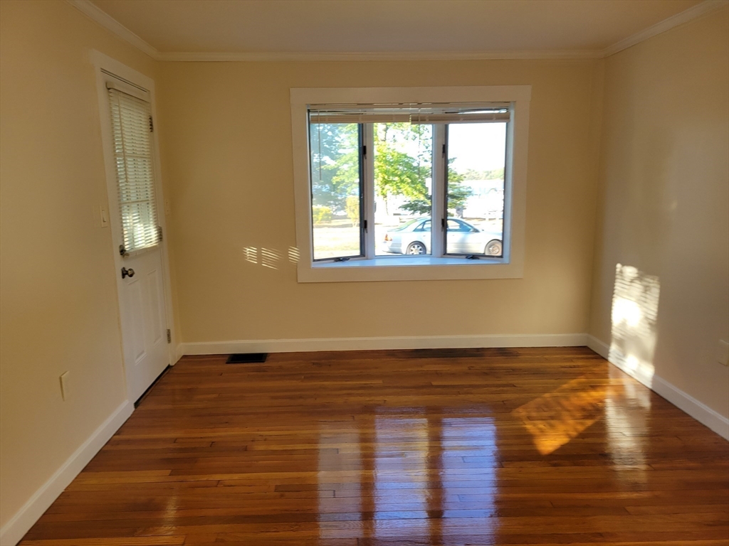 31 Avalon Avenue, Unit 1 Quincy, MA 02169 - Photo 2 of 10 a view of an empty room with wooden floor and a window