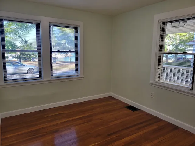 a view of a room with wooden floor and windows