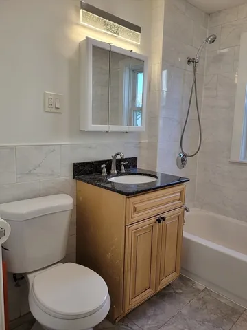 a bathroom with a granite countertop toilet sink and shower