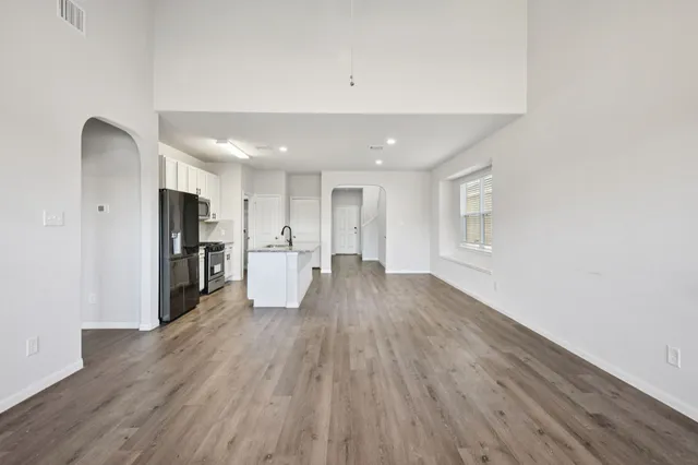 a view of a kitchen with wooden floor and a refrigerator