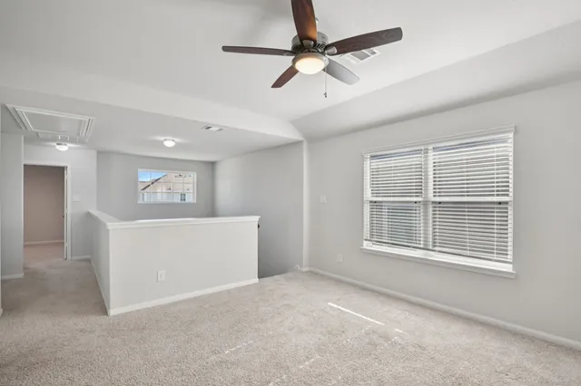 an empty room with a window and a fan