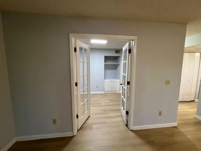 a view of an empty room and a ceiling fan and window