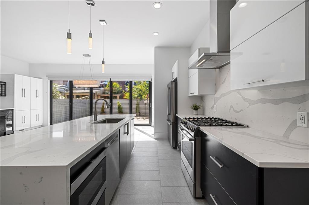 127 1/2 Banner Way Pittsburgh, PA 15201 - Photo 8 of 48 a open kitchen with stainless steel appliances granite countertop a sink a stove and a wooden floors