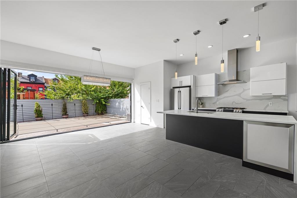 127 1/2 Banner Way Pittsburgh, PA 15201 - Photo 10 of 48 a large kitchen with stainless steel appliances kitchen island granite countertop a sink and cabinets
