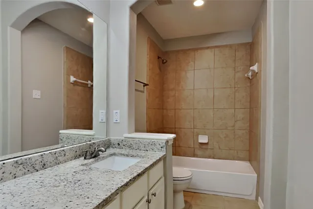 a bathroom with a granite countertop sink a toilet and shower