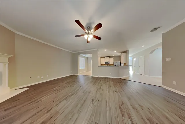 a view of empty room with wooden floor and window