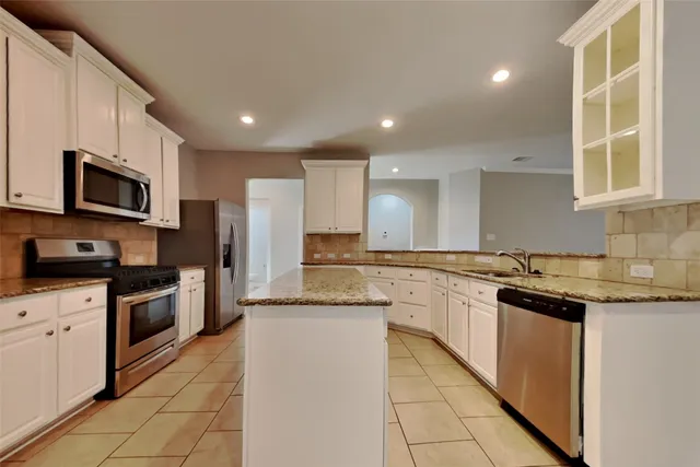 a kitchen with stainless steel appliances granite countertop refrigerator sink and cabinets