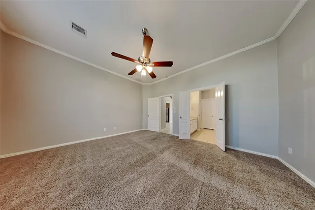 a view of an empty room with a chandelier fan