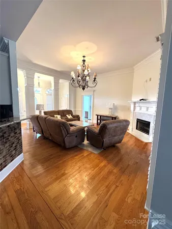 a living room with furniture a chandelier and fireplace