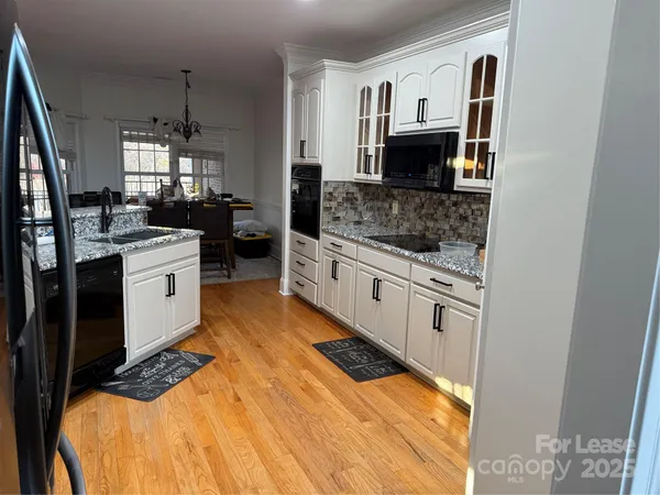 a kitchen with stainless steel appliances kitchen island granite countertop a stove and a sink