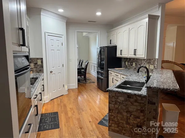 a kitchen with stainless steel appliances granite countertop a refrigerator stove and sink