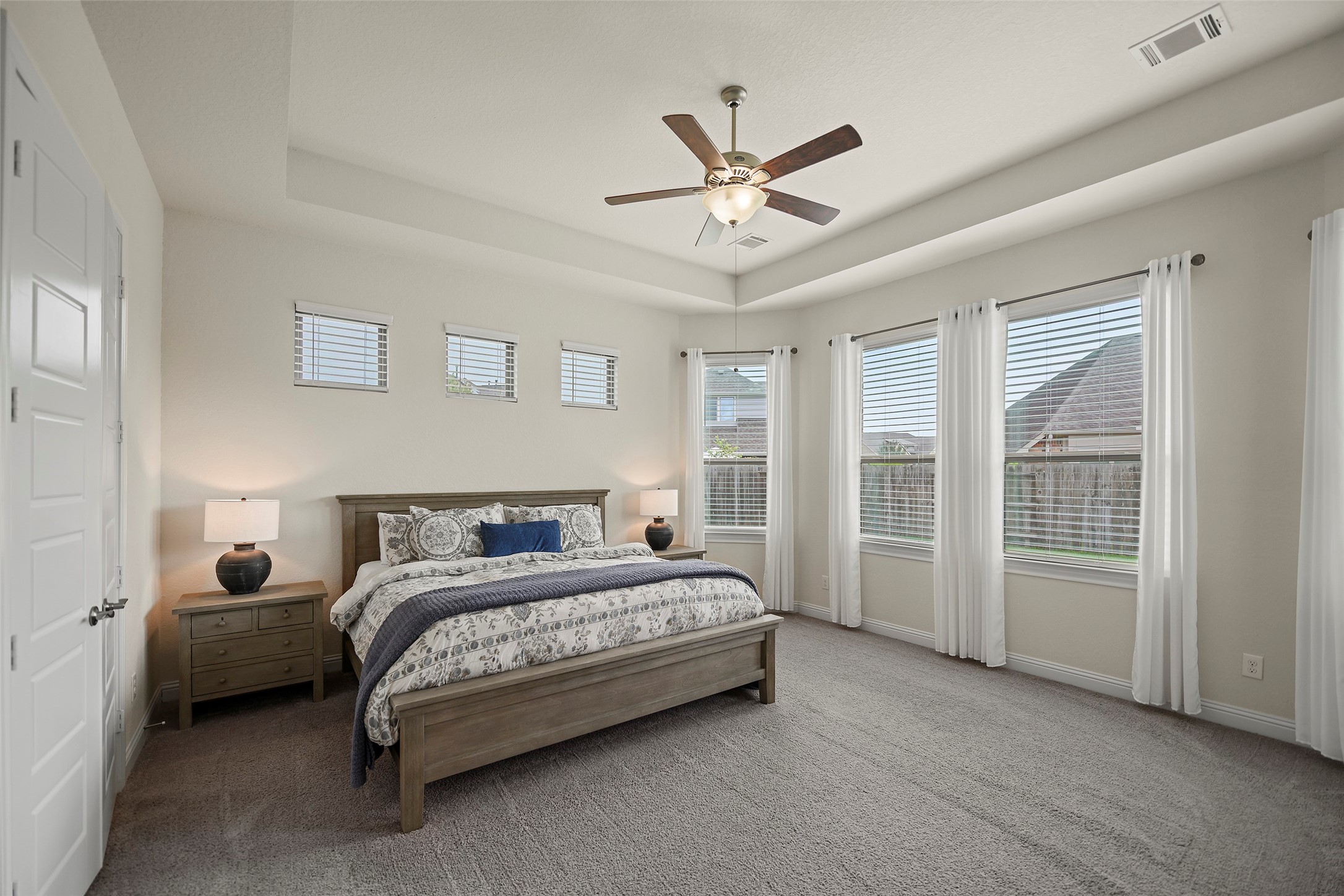 20330 Rosegold Way Spring, TX 77379 - Photo 8 of 48 Spacious primary suite featuring a tray ceiling, oversized layout, and large windows for natural light.