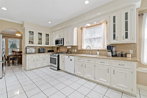 a kitchen with granite countertop cabinets stainless steel appliances and a window