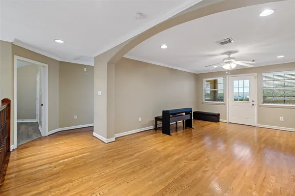 a view of empty room with wooden floor and furniture