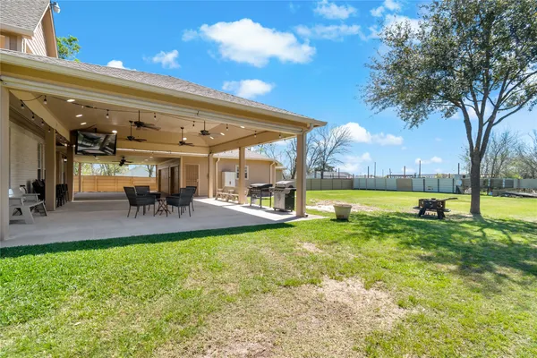 a patio with table and chairs and a large tree