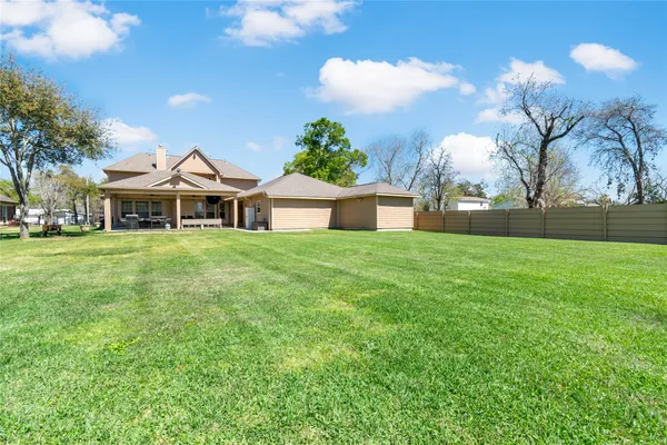 a front view of a house with a garden and trees