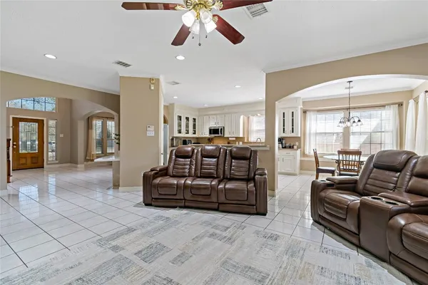 a living room with furniture a large window and a chandelier