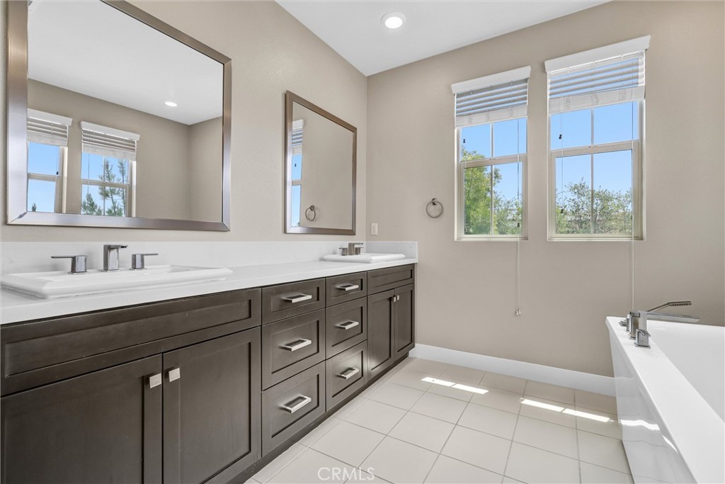 111 Drama Irvine, CA 92618 - Photo 17 of 28 a spacious bathroom with a granite countertop double vanity sink a mirror and a bathtub