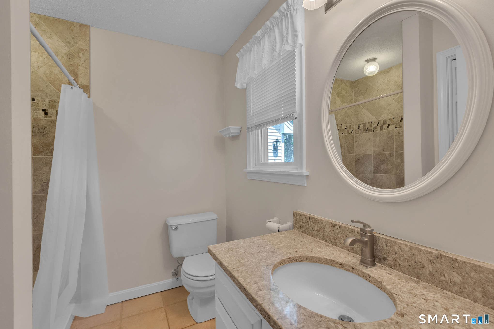 81 Oldefield Farms Road, Unit 81 Enfield, CT 06082 - Photo 25 of 35 a bathroom with a granite countertop toilet a sink and mirror