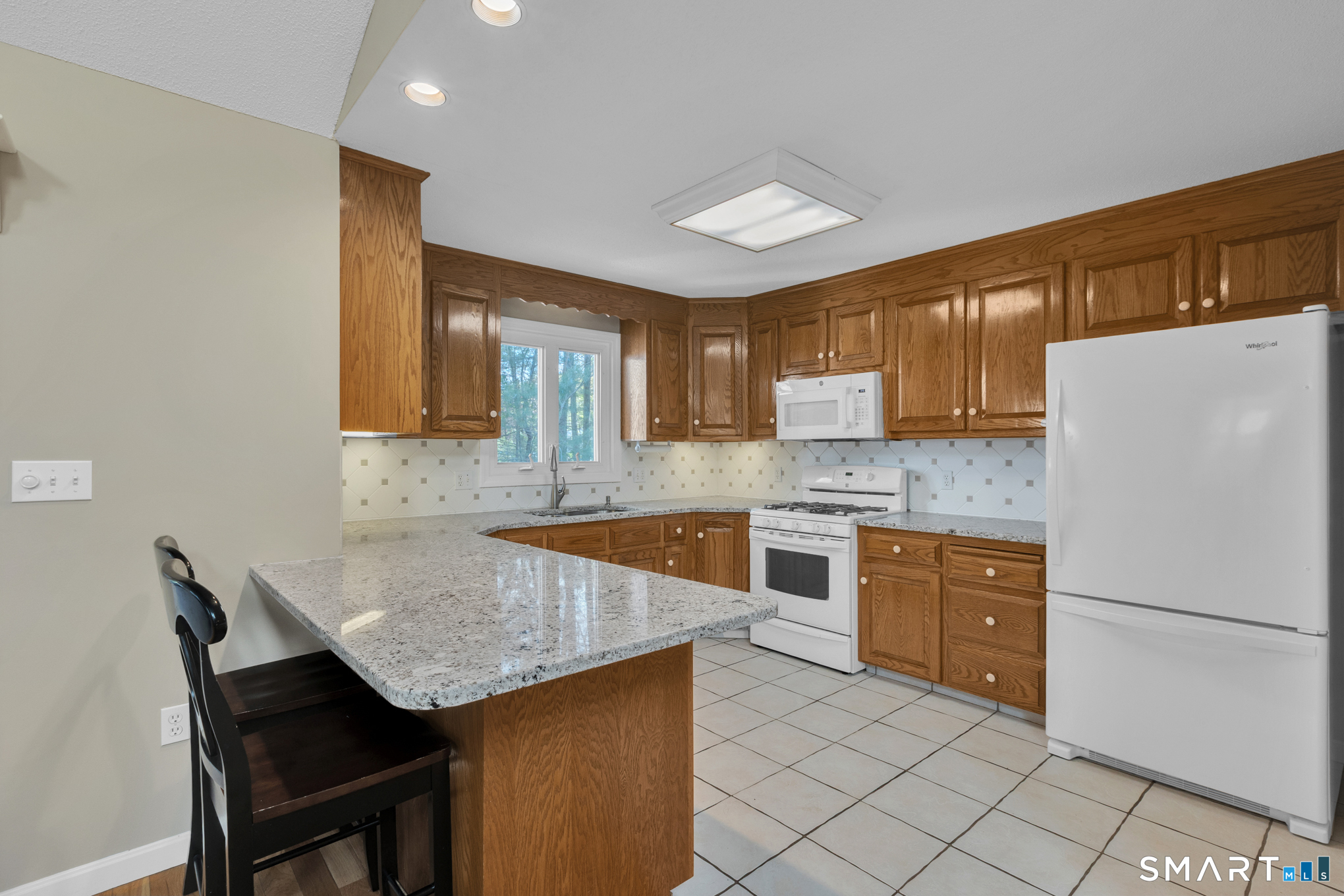 81 Oldefield Farms Road, Unit 81 Enfield, CT 06082 - Photo 8 of 35 a kitchen with granite countertop a counter space and cabinets