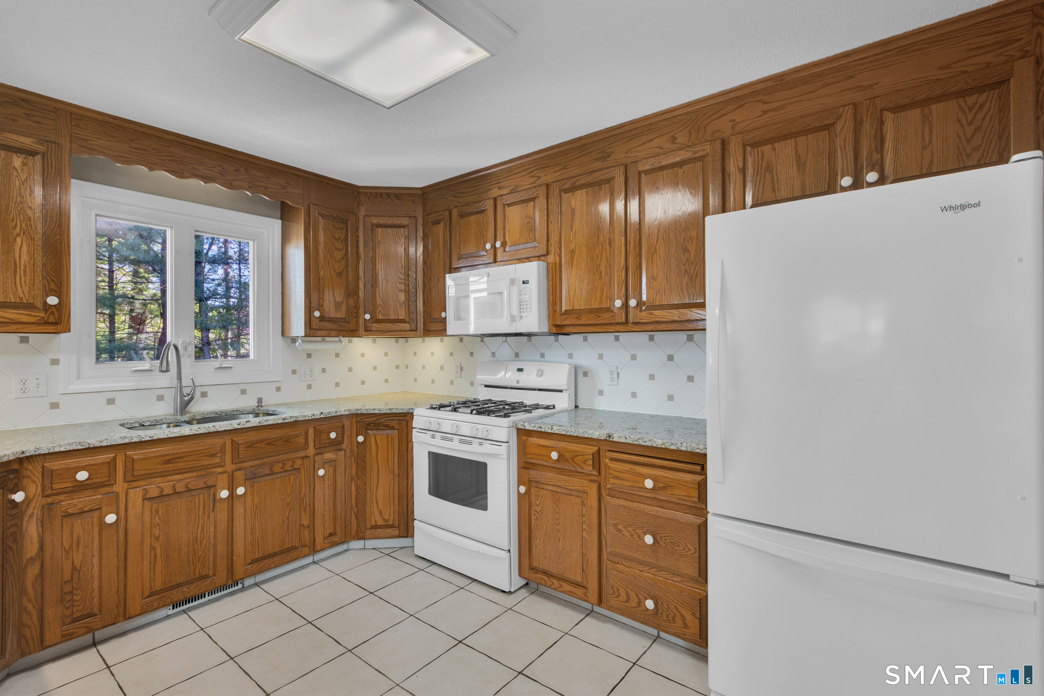 81 Oldefield Farms Road, Unit 81 Enfield, CT 06082 - Photo 9 of 35 a kitchen with a cabinets and white appliances