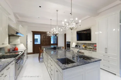 a kitchen with stainless steel appliances granite countertop a sink and a stove