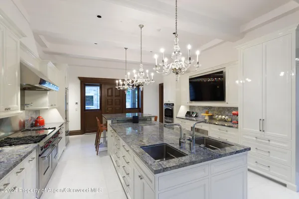 a kitchen with stainless steel appliances granite countertop a sink and a stove