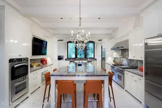 a kitchen with kitchen island granite countertop a sink and refrigerator