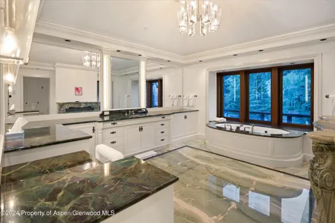 a kitchen with white cabinets and window