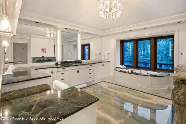 a kitchen with white cabinets and window