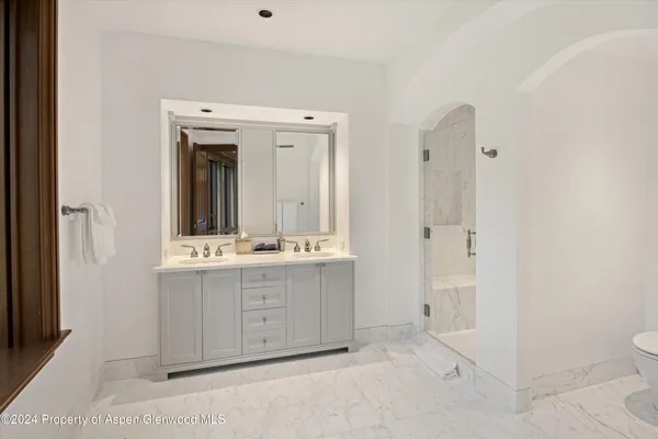 a bathroom with a double vanity sink mirror and toilet