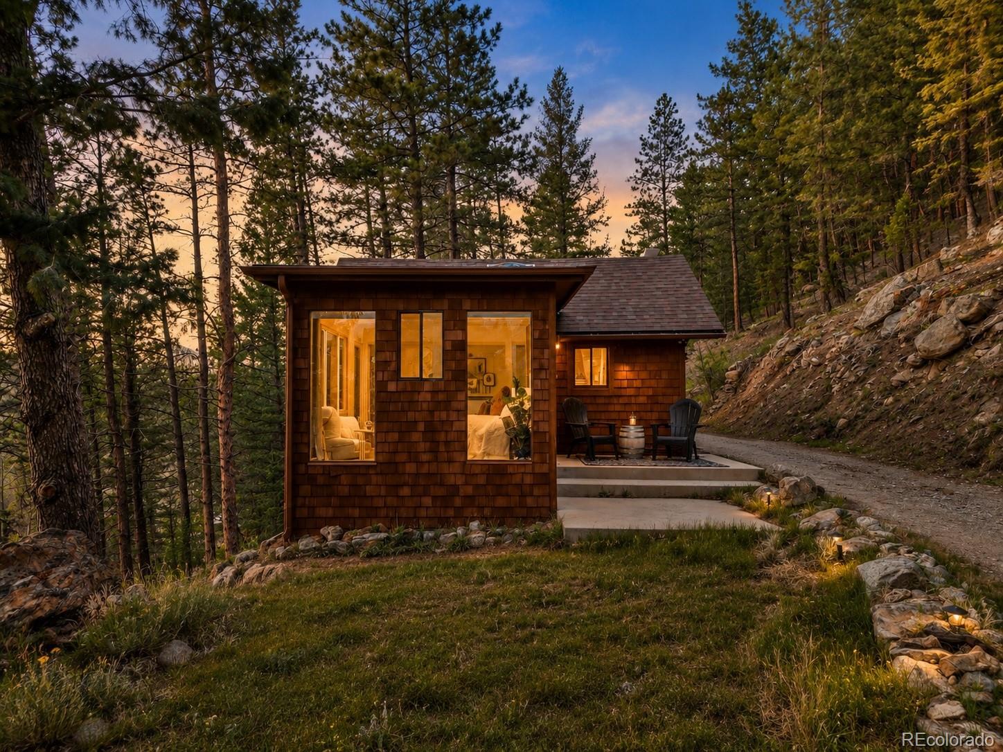 7520 South Blue Creek Road Evergreen, CO 80439 - Photo 1 of 22 a front view of a house with garden