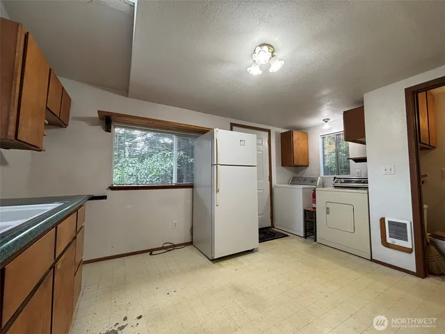 a kitchen with white cabinets and white appliances