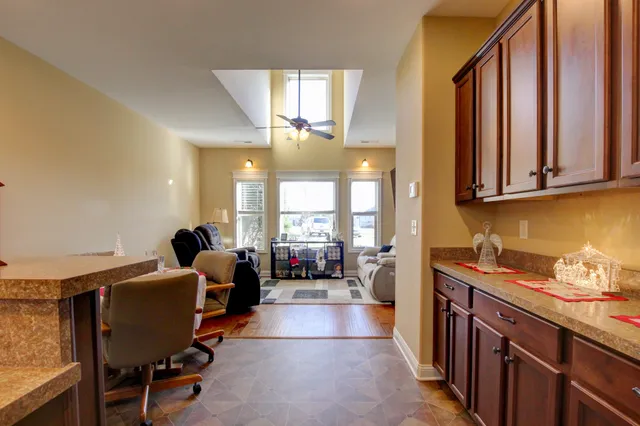 a room with stainless steel appliances kitchen island granite countertop furniture and a large window