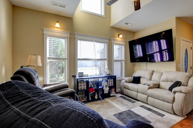 a living room with furniture ceiling fan and a window