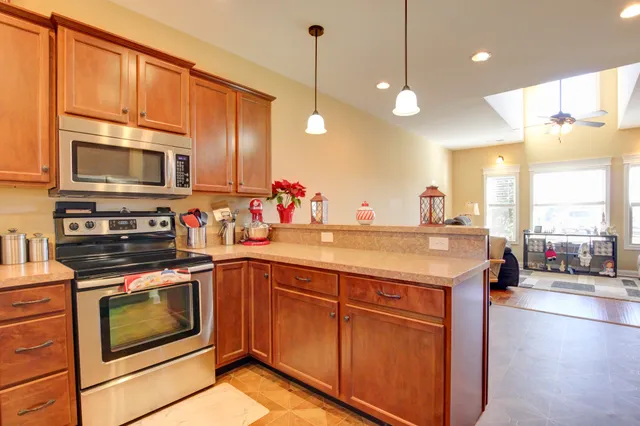 a kitchen with stainless steel appliances granite countertop a stove a sink and a microwave