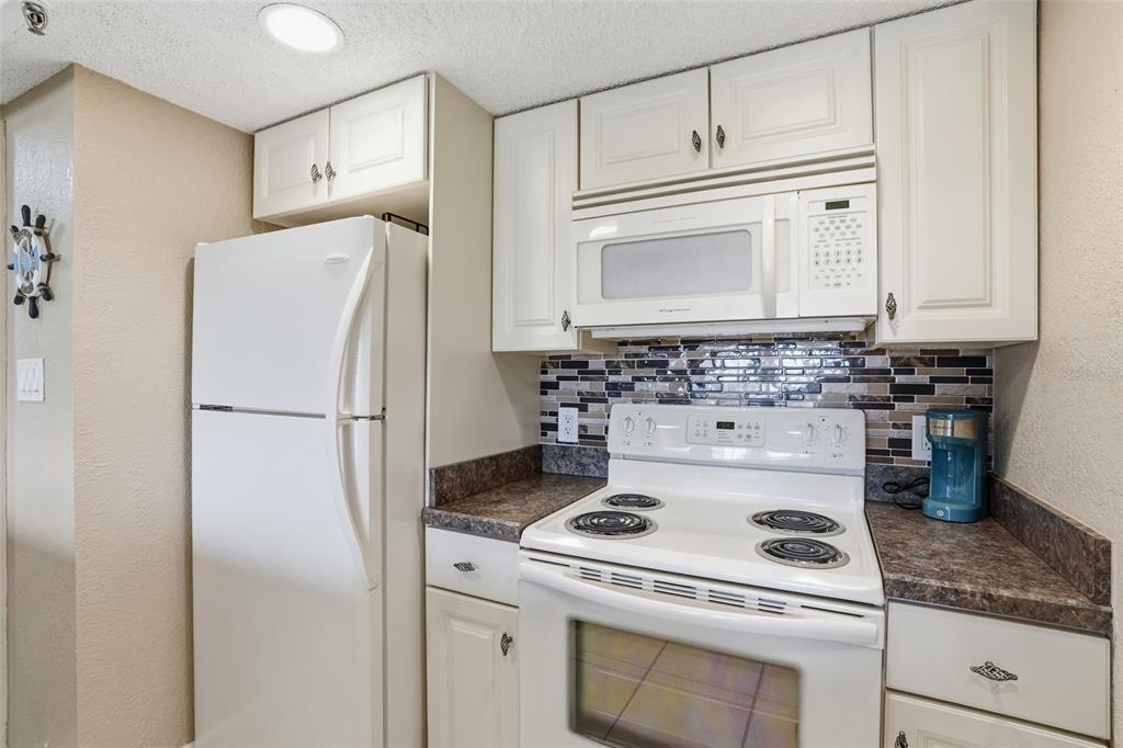 3170 Matecumbe Key Road, Unit 127 Punta Gorda, FL 33955 - Photo 4 of 22 a kitchen with refrigerator a stove a sink and cabinets
