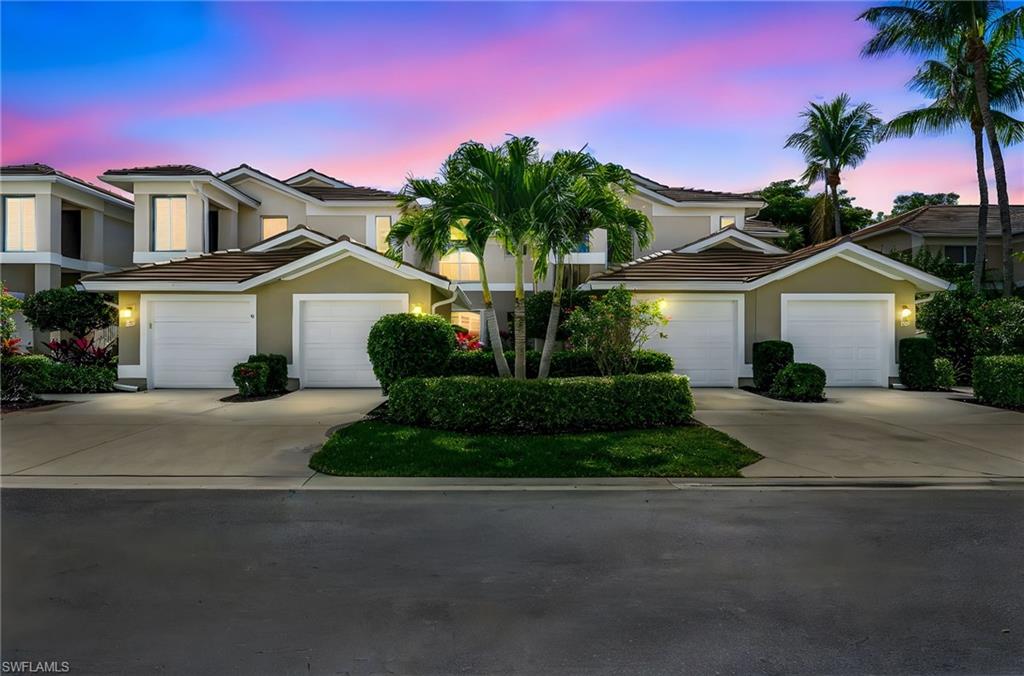 View of front of property featuring stucco siding, driveway, a garage, and a tiled roof