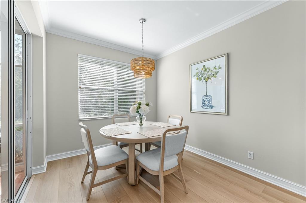 817 Carrick Bend Circle, Unit 102 Naples, FL 34110 - Photo 13 of 36 Dining area with crown molding and light wood-style flooring