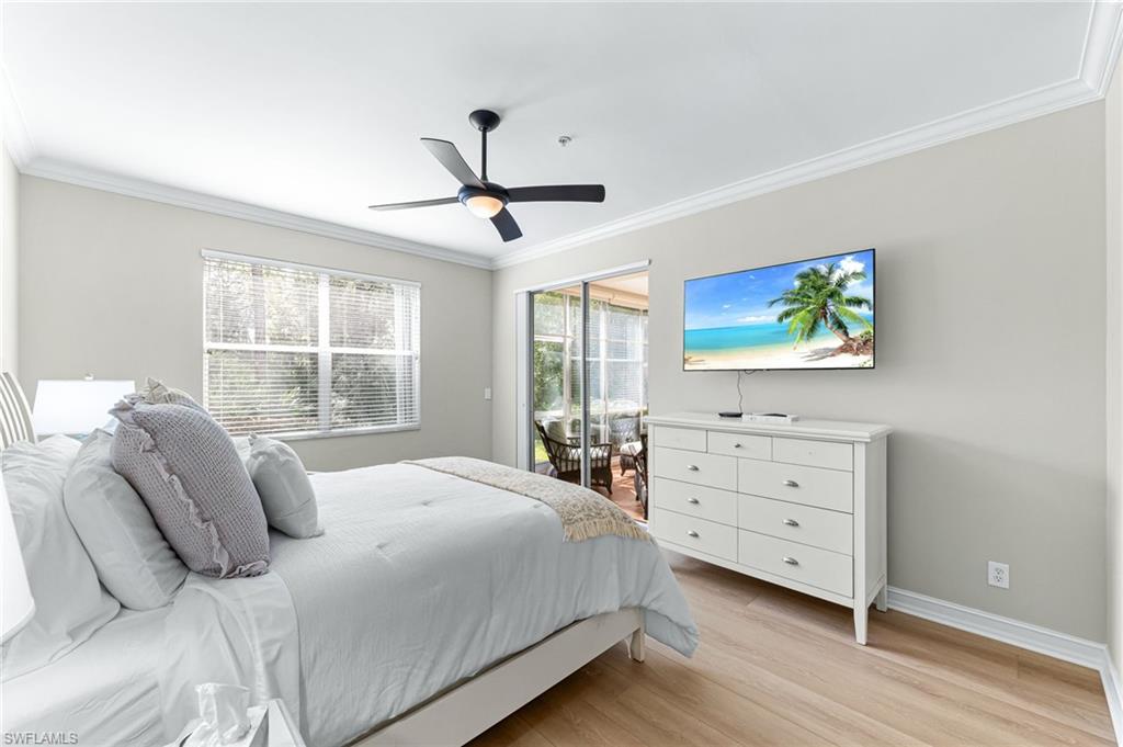 817 Carrick Bend Circle, Unit 102 Naples, FL 34110 - Photo 17 of 36 Bedroom with light wood-style floors, ceiling fan, crown molding, and access to exterior