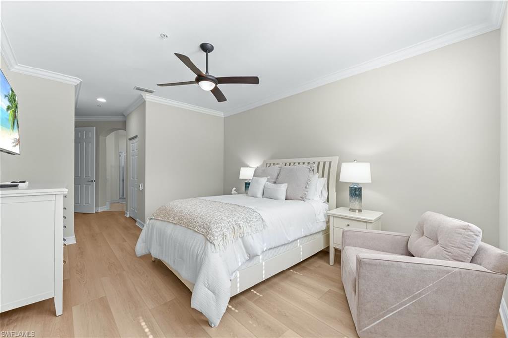 817 Carrick Bend Circle, Unit 102 Naples, FL 34110 - Photo 18 of 36 Bedroom with ornamental molding, light wood-style floors, arched walkways, recessed lighting, and a ceiling fan