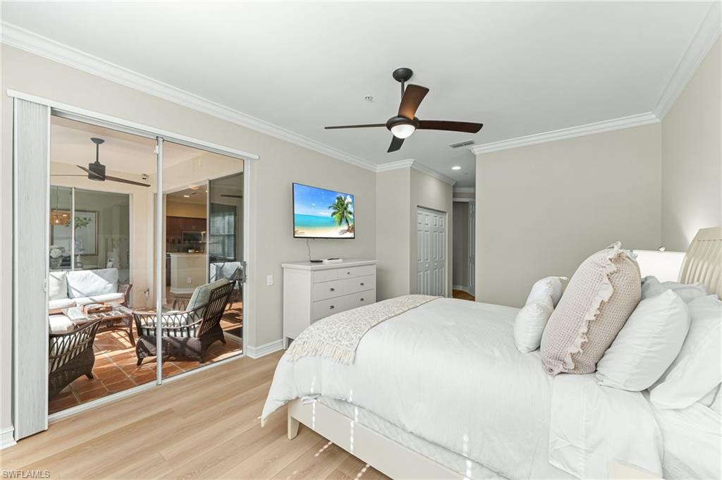 817 Carrick Bend Circle, Unit 102 Naples, FL 34110 - Photo 19 of 36 Bedroom with a closet, wood finished floors, a ceiling fan, and ornamental molding
