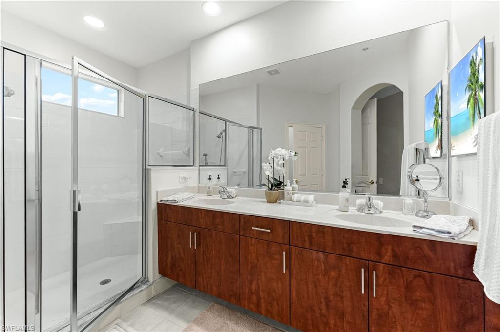 817 Carrick Bend Circle, Unit 102 Naples, FL 34110 - Photo 20 of 36 Bathroom featuring double vanity, a stall shower, light tile patterned flooring, and recessed lighting