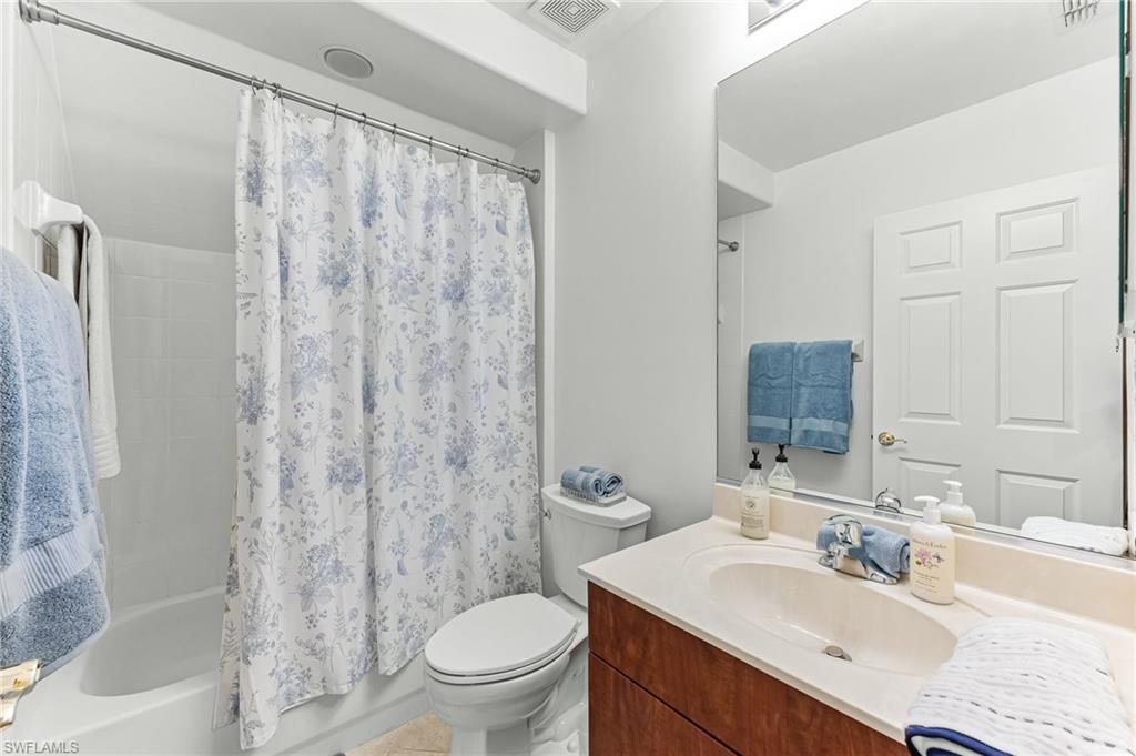 817 Carrick Bend Circle, Unit 102 Naples, FL 34110 - Photo 22 of 36 Full bathroom featuring vanity and shower / bath combo with shower curtain
