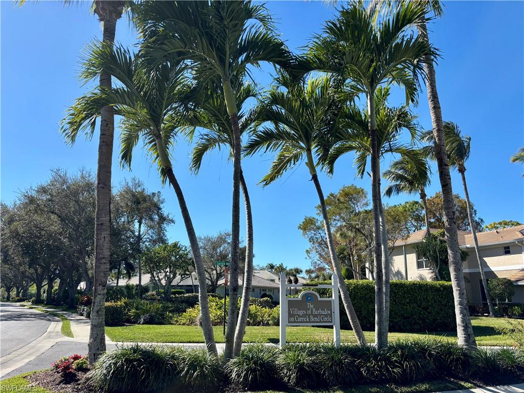 817 Carrick Bend Circle, Unit 102 Naples, FL 34110 - Photo 32 of 36 Community sign with a yard