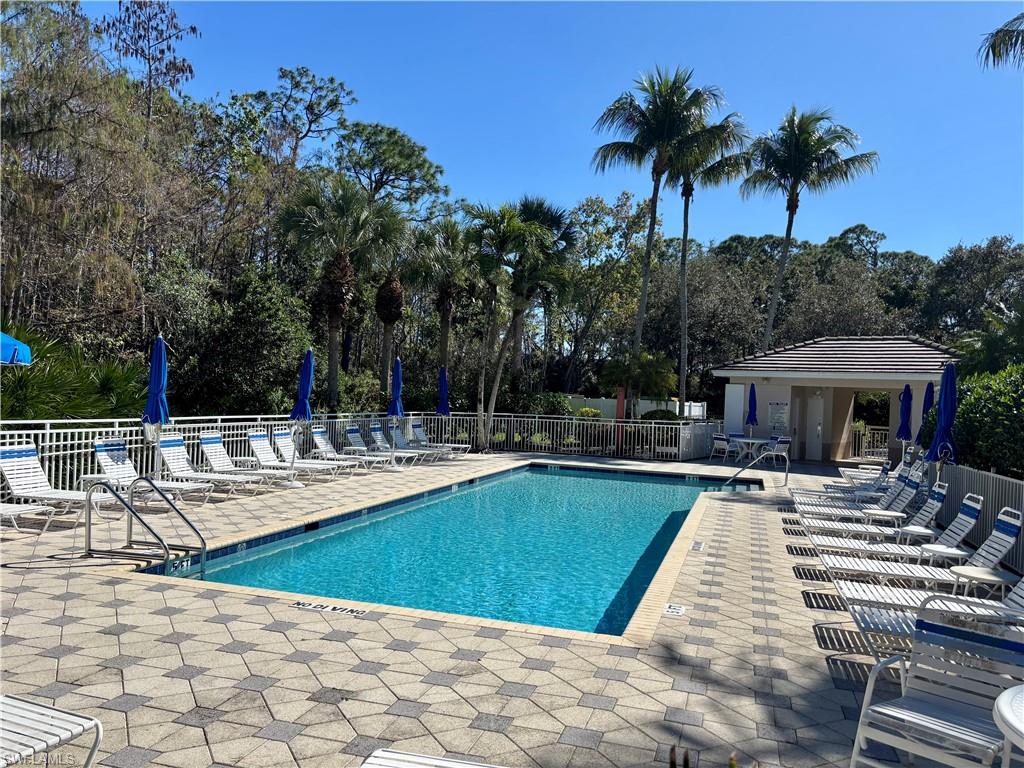 817 Carrick Bend Circle, Unit 102 Naples, FL 34110 - Photo 34 of 36 Community pool featuring a patio and view of scattered trees