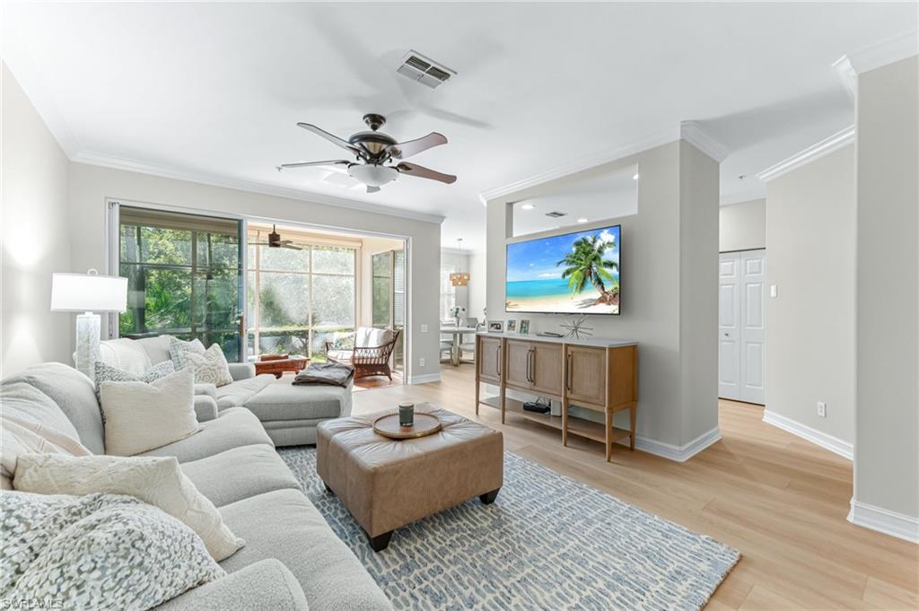 817 Carrick Bend Circle, Unit 102 Naples, FL 34110 - Photo 6 of 36 Living area with ornamental molding, light wood finished floors, and a ceiling fan