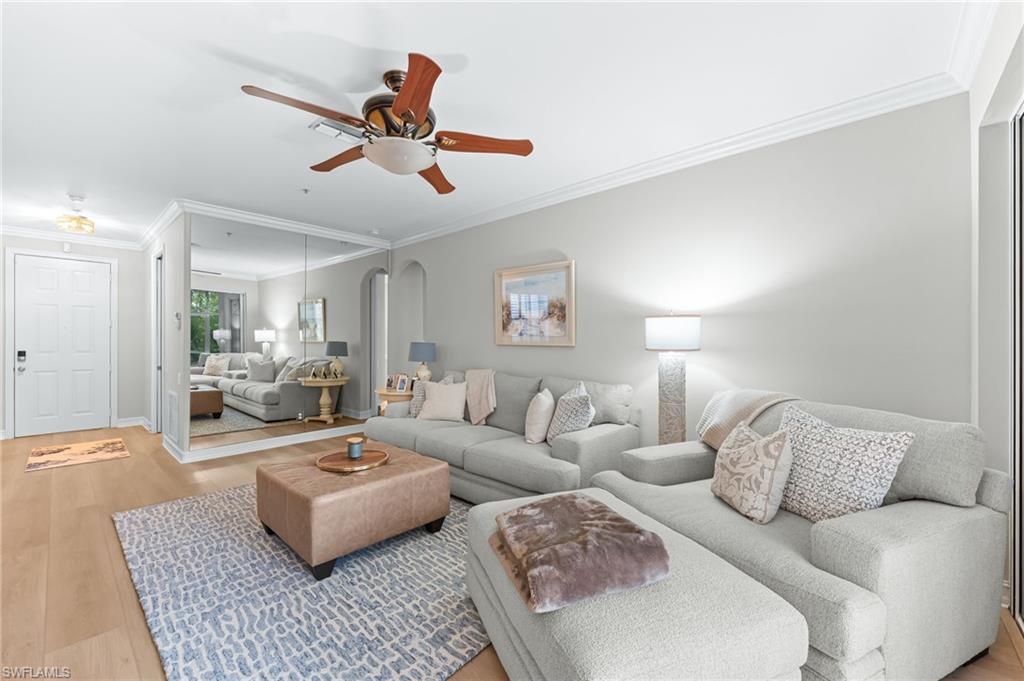 817 Carrick Bend Circle, Unit 102 Naples, FL 34110 - Photo 7 of 36 Living room featuring light wood finished floors, ornamental molding, arched walkways, and ceiling fan