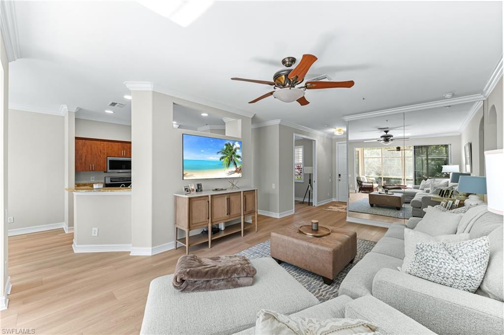 817 Carrick Bend Circle, Unit 102 Naples, FL 34110 - Photo 8 of 36 Living room with ceiling fan, ornamental molding, and light wood finished floors